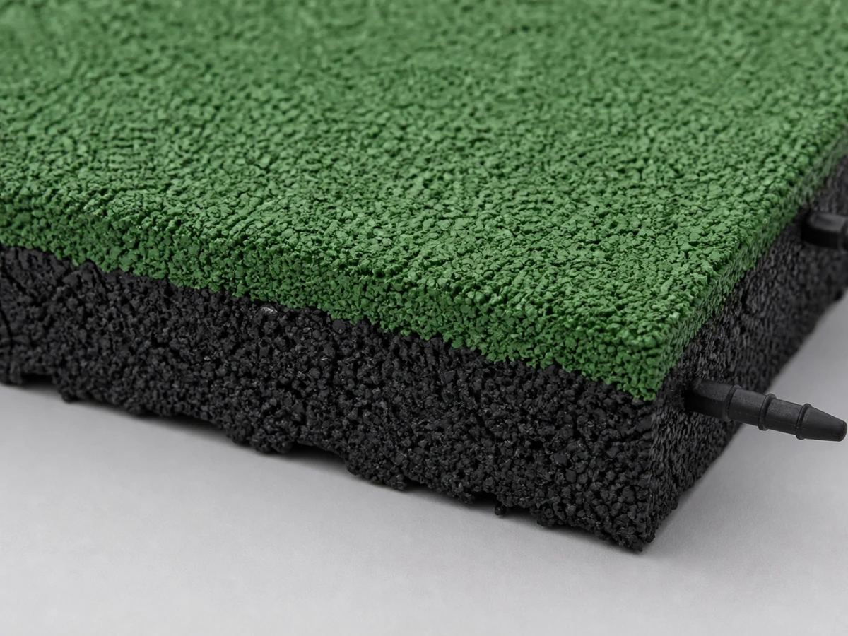 Detail zelenej granulátovej vrchnej vrstvy a čiernej hrany 60 mm gumovej dlažby Petra